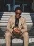 Stylish man in a suit and sunglasses poses.